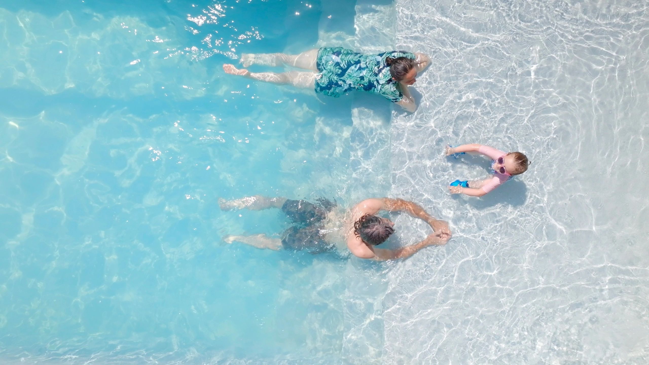 Guests relaxing in a tropical-style pool